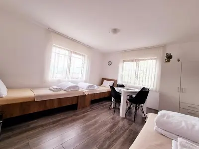 a room with three beds and a table and chairs at Temački amanet in Pirot