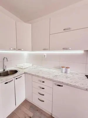 a white kitchen with white cabinets and a sink at Temački amanet in Pirot