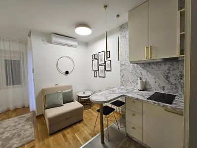 a kitchen with a counter and a table in a room at Studio apartman Gold in Vrnjci