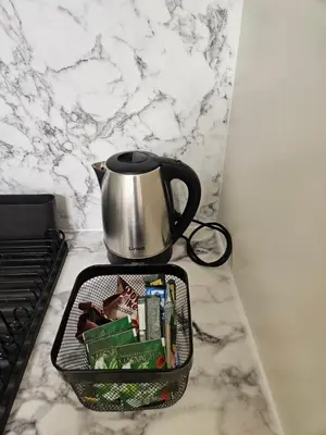 a tea pot sitting on top of a counter with a basket of food at Studio apartman Gold in Vrnjci