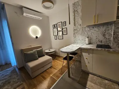 a kitchen with a couch and a table in a room at Studio apartman Gold in Vrnjci