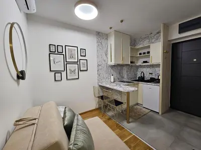 a living room with a couch and a kitchen at Studio apartman Gold in Vrnjci