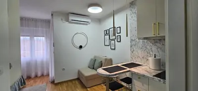 a kitchen with a counter and a table in a room at Studio apartman Gold in Vrnjci