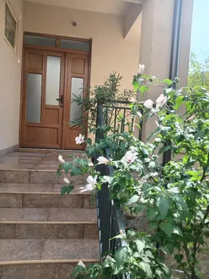 a front door of a house with a fence and flowers at Palamar in Kuršumlija