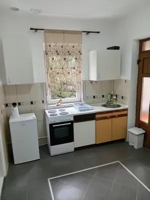 a small kitchen with white appliances and a window at Palamar in Kuršumlija