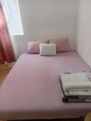 a white bed with pink pillows in a room at Palamar in Kuršumlija