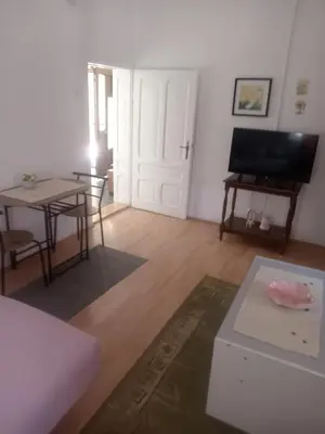 a living room with a table and a room with a door at Palamar in Kuršumlija
