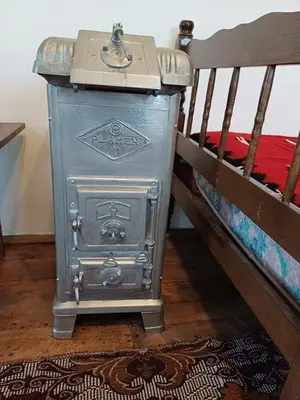 a metal stove sitting next to a bunk bed at Seosko Domaćinstvo Jevtić in Ždraljica