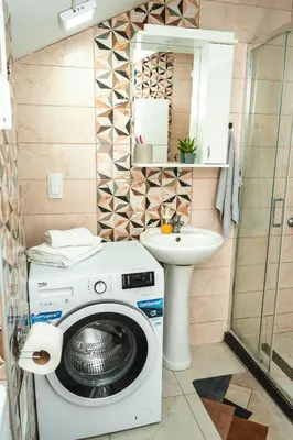 a bathroom with a washing machine and a sink at Apartman Leskovčanka in Leskovac