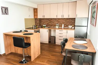 a kitchen with a wooden island and a table at Apartman Leskovčanka in Leskovac