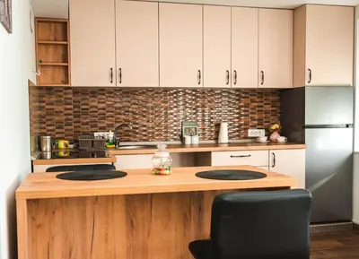 a kitchen with white cabinets and a wooden counter top at Apartman Leskovčanka in Leskovac