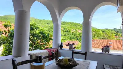 a balcony with a table and two vases on the windows at Vila Kruna in Pirot