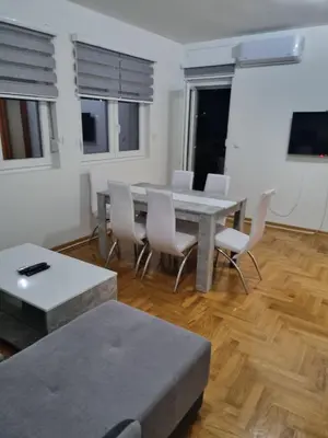 a living room with a dining room table and chairs at Apartman BN in Vrnjačka Banja