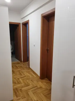 an empty room with two doors and a wooden floor at Apartman BN in Vrnjačka Banja