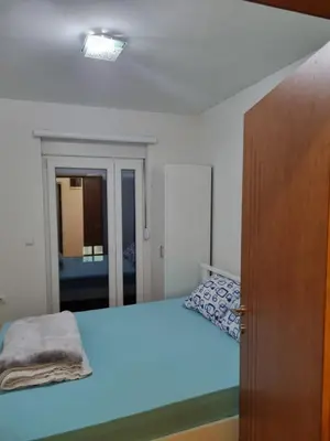 a bedroom with a bed and a wooden door at Apartman BN in Vrnjačka Banja