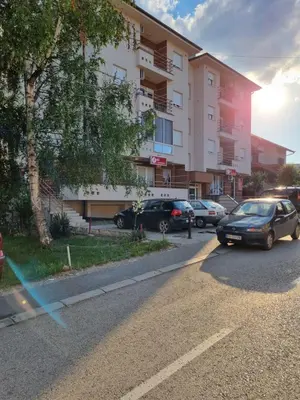 a street with cars parked in front of a building at Apartman BN in Vrnjačka Banja