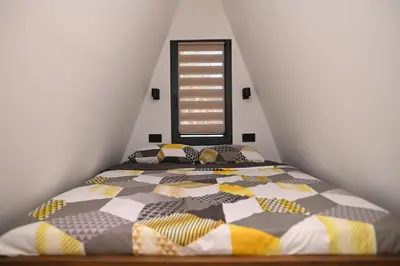a bedroom with a bed with a colorful comforter at Horizonti in Vrmdža