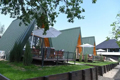 a group of chairs and umbrellas in front of a building at Horizonti in Vrmdža