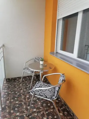 a table and two chairs and a table and a window at Apartman Zapadni Kej Pirot in Pirot