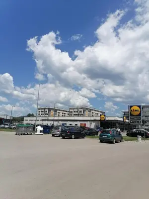 a parking lot with cars parked in front of a building at Apartman Zapadni Kej Pirot in Pirot