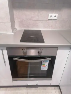 a stove top oven sitting under a counter in a kitchen at Apartman Zapadni Kej Pirot in Pirot