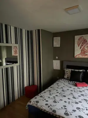 a bedroom with a bed with a black and white comforter at Vanila in Leskovac
