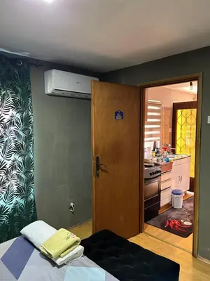 a room with a bed and a kitchen with a door at Vanila in Leskovac