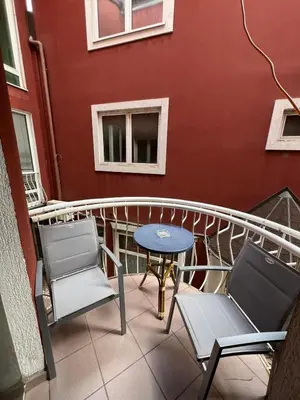 a balcony with chairs and a table and a window at Apartman Jabuka in Paraćin