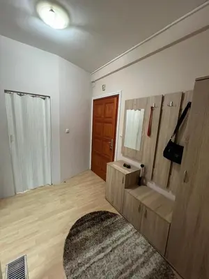 a living room with a bench and a wooden door at Apartman Jabuka in Paraćin