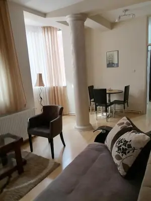 a living room with a couch and a table and chairs at Apartman Jabuka in Paraćin