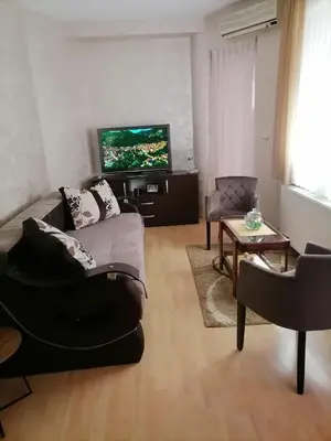 a living room with a couch and a flat screen tv at Apartman Jabuka in Paraćin