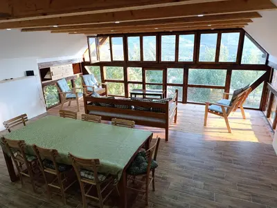 a room with a table and chairs and a piano at Magarija 1 in Dimitrovgrad