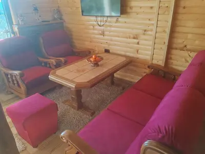 a living room with a table and two chairs at Kucica od drveta 1 in Kopaonik