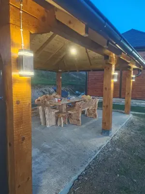 a wooden pergola with a picnic table under it at Kucica od drveta 1 in Kopaonik