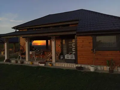 a log cabin with a sunset in the background at Kucica od drveta 1 in Kopaonik