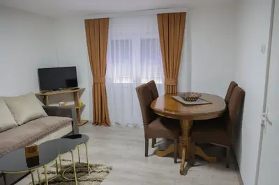 a living room with a table and a couch at Apartman Nikolić in Kuršumlija