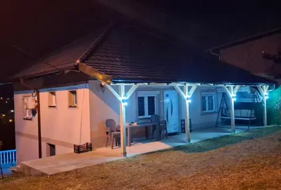 a house with blue lights on a patio at night at Apartman Nikolić in Kuršumlija