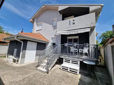 a house with a balcony with chairs on it at Vila MINJA in Soko Banja