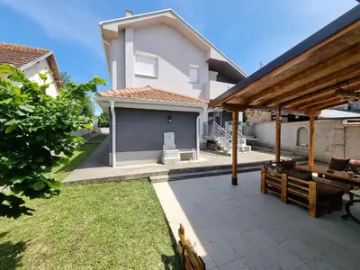 a house with a patio with a table at Vila MINJA in Soko Banja