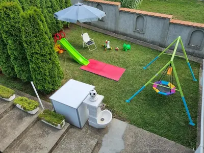 an aerial view of a backyard with a playground and an umbrella at Vila MINJA in Soko Banja