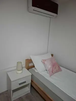 a small bedroom with a bed with a night stand at MAGNIV Home in Vranje