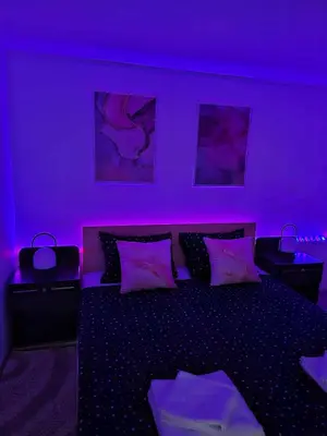 a purple bedroom with a bed with purple lights at MAGNIV Home in Vranje