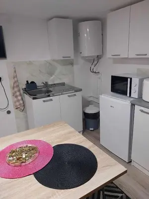 a kitchen with a table with a plate of food on it at MAGNIV Home in Vranje