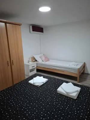 a bedroom with a bed and two white towels on the floor at MAGNIV Home in Vranje