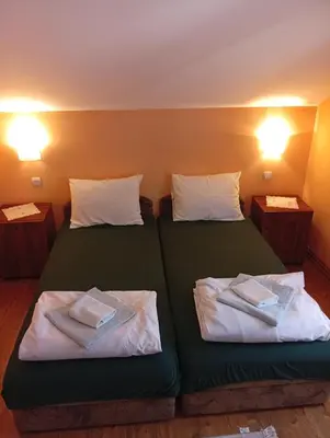 a room with two beds with towels on them at Apartmani Petrović in Soko Banja