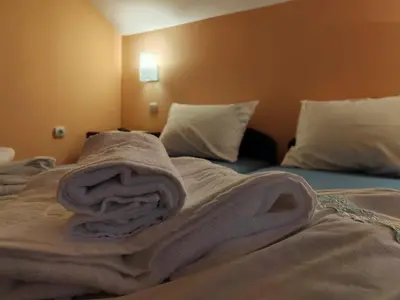 a blanket laying on top of a bed at Apartmani Petrović in Soko Banja
