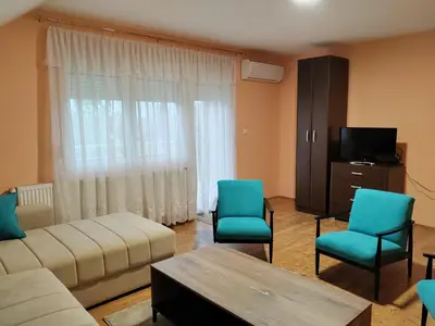 a living room with a couch and chairs and a tv at Apartmani Petrović in Soko Banja