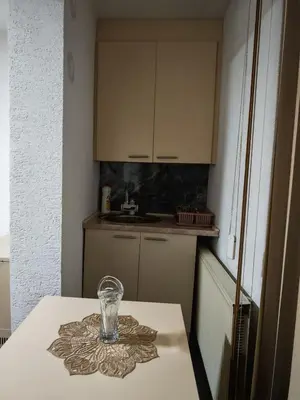 a glass on a table in a small kitchen at Studio D&I in Vranje