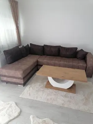 a living room with a brown couch and a coffee table at Apartman Jelena in Vranje