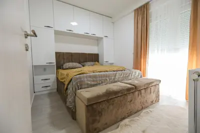 a bedroom with a bed and a large window at Apartman Jelena in Vranje